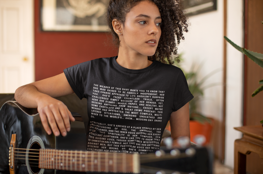 Mixed race 20-something year old, female guitarist, sits on a chair pondering her future with black acoustic guitar in hand